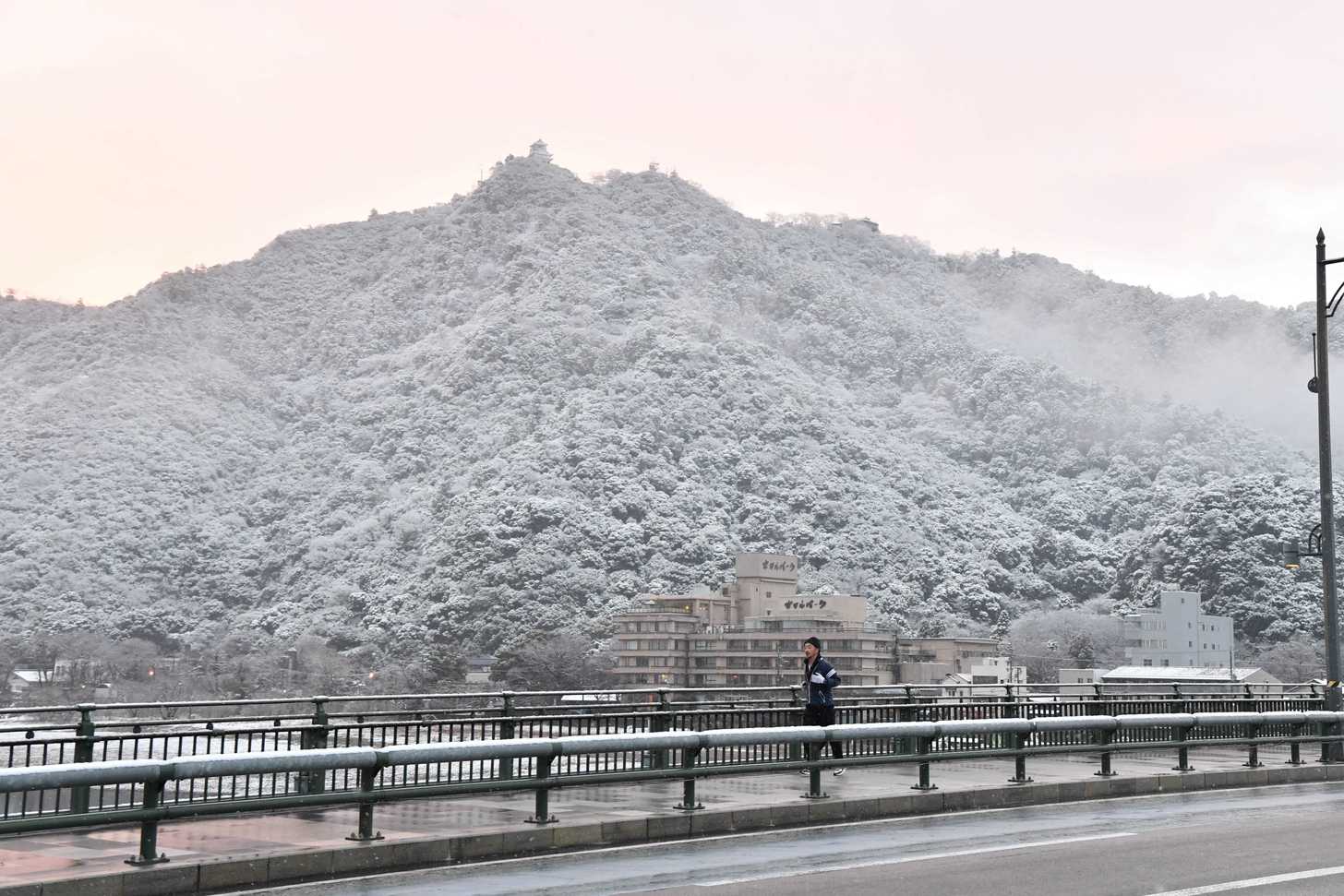 真っ白に雪化粧した金華山＝２３日午前７時、岐阜市の長良橋から望む