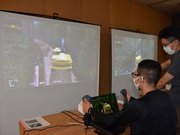 林業機械シミュレーターで伐木を体験する参加者＝美濃市曽代、県森林文化アカデミー