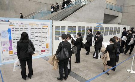 　合同会社説明会で掲示板を見る学生ら＝３月１日、千葉市