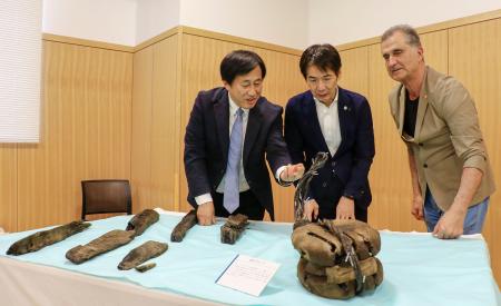 　「エルトゥールル号」の遺物を見る（左から）奈良大の今津節生学長、和歌山県串本町の田嶋勝正町長、トルコの水中考古学者トゥファン・トゥランルさん＝２９日午後、串本町役場