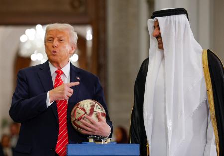 　カタールで開かれた記念行事でサッカーボールを持つトランプ米大統領（左）とタミム首長＝１４日（ロイター＝共同）