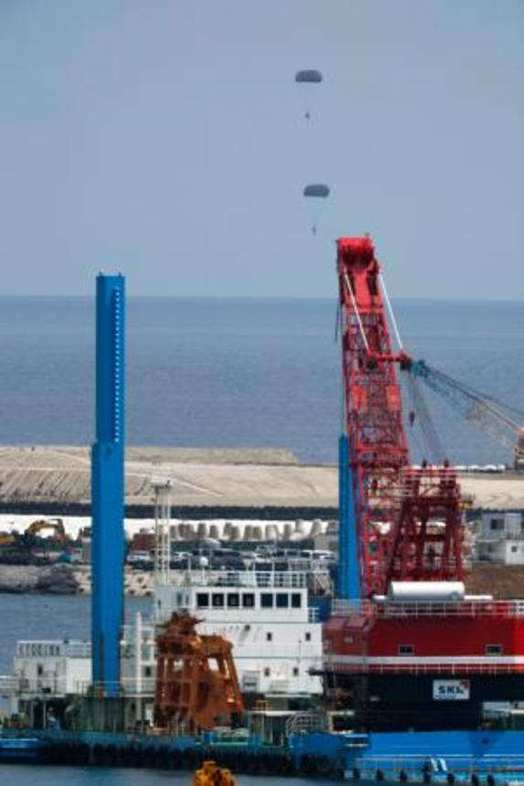 　米海兵隊が沖縄県名護市辺野古沖で実施したパラシュート降下訓練。手前は米軍普天間飛行場の移設に向けた工事が進む大浦湾＝２１日午後