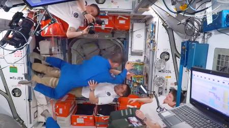 　国際宇宙ステーションに到着した油井亀美也飛行士（中央上）を出迎える大西卓哉飛行士（同下）＝２日（ＮＡＳＡ提供）