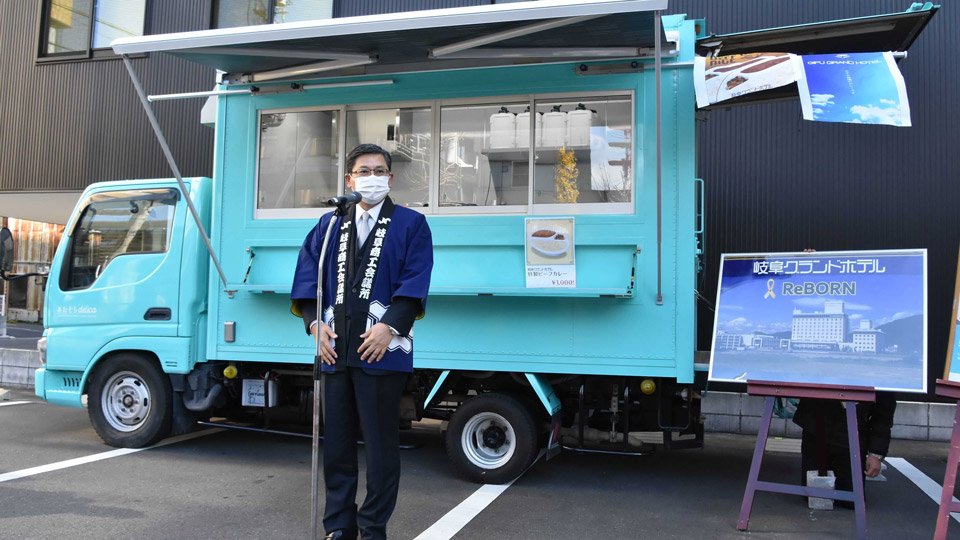 無料で貸し出すキッチンカーの前であいさつする村瀬幸雄会頭＝岐阜市神田町、岐阜商工会議所