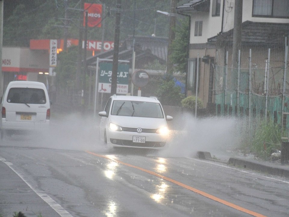 大雨の影響で水しぶきを上げて走る車＝２日午後２時５０分、関市志津野