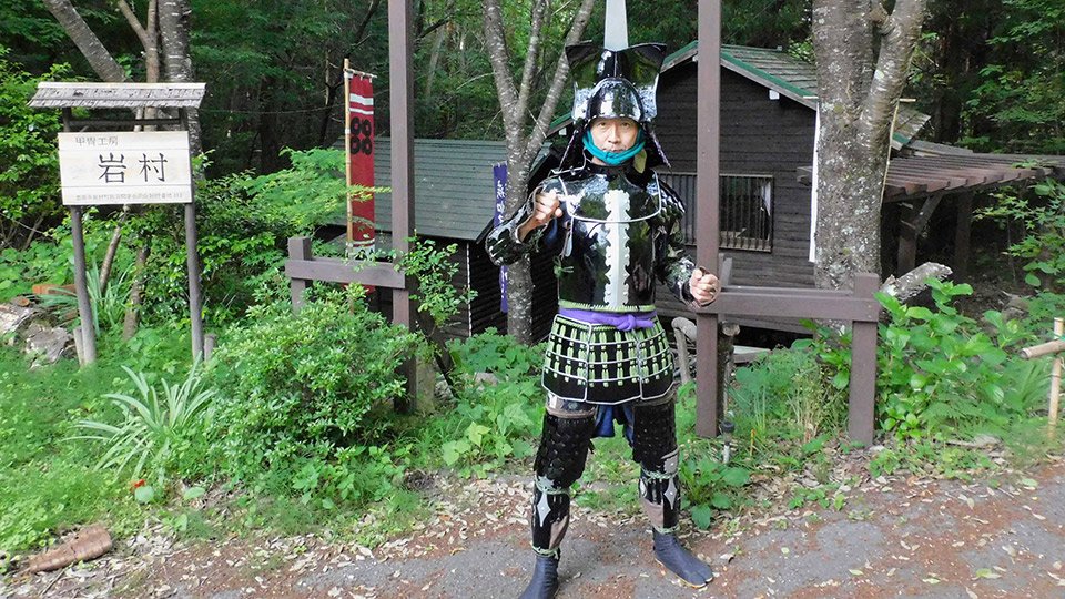 工房の前で甲冑姿でポーズをとる市島英司さん＝恵那市岩村町