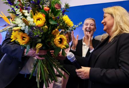　ベルリン特別市の議会選で投票が終わり、出口調査の結果を受けて花束を贈られる候補者（右）＝２０日、ベルリン（ロイター＝共同）