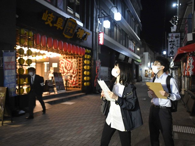 まん延防止等重点措置の適用初日、玉宮地区の飲食店の営業状況を調べる岐阜市職員＝９日午後８時１１分、同市住田町