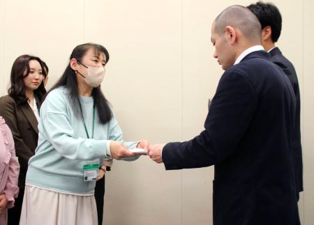 　「包括的性教育」の学校現場への導入を求め、文科省の担当者（右）に要望書を手渡す市民グループの佐藤晴美代表＝３０日午後、国会