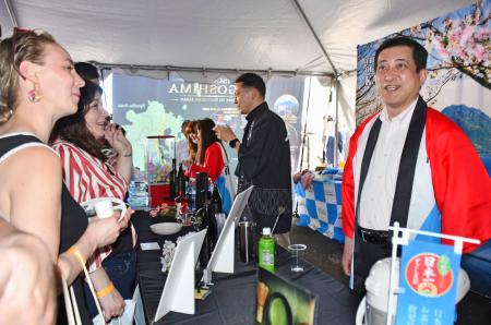 　「全米桜祭り」の日本ストリートフェスティバルで、鹿児島県の県産品や観光地をＰＲする塩田康一知事（右端）＝１１日、米ワシントン（共同）