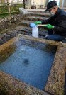 地下１３６メートルの地下から湧き出る水で満たされた井戸槽。「鎮守の森」には水が流れる透き通った音が響く＝大垣市加賀野、加賀野八幡神社