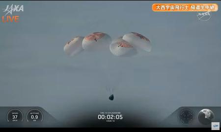 　パラシュートを開いて着水に向かう宇宙船クルードラゴン＝９日、米カリフォルニア州沖（ＪＡＸＡ／ＮＡＳＡの中継から）