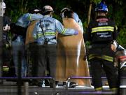 　閉じ込められた観覧車から救助され、消防隊員に毛布をかけられる乗客＝２６日午前２時４２分、大阪府吹田市