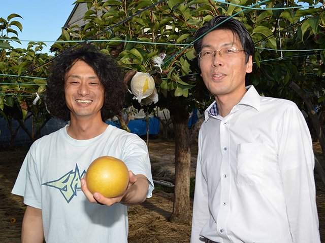 梨畑で育てた梨を手に意気込みを見せる川瀬嘉樹さん（左）とバイヤーの中野直浩さん＝大垣市青柳町