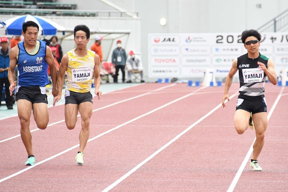 男子１００メートル（視覚障害Ｔ１２）決勝で優勝した山路竣哉（右）と２位の兄喬哉（左から２人目）＝長良川競技場