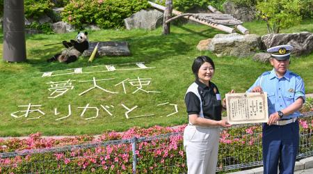 　和歌山県警から感謝状を受け取るアドベンチャーワールドの中尾建子副園長（左）。奥はジャイアントパンダの「楓浜」＝２０日午前、和歌山県白浜町