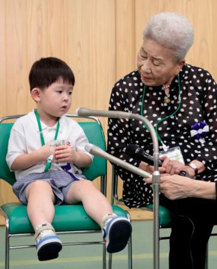 　全国戦没者追悼式を前に取材に応じる最年少参列者の片山純矢ちゃん。右は曽祖母の伊藤早苗さん＝１５日午前１０時２１分、東京・日本武道館