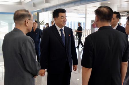 　愛知・名古屋アジア大会に参加するため、平壌国際空港を出発する北朝鮮の金日国体育相（中央）＝１５日（共同）