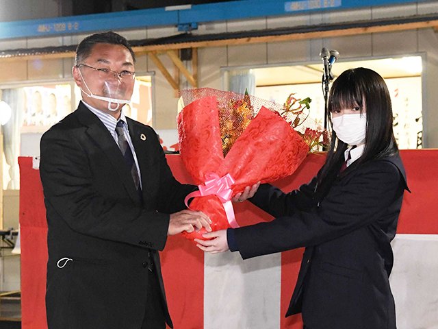 長女の奈都さんから花束を受け取る横川真澄さん＝海津市海津町馬目