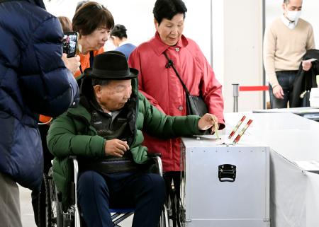 　浜松市役所で期日前投票する袴田巌さん。右は姉ひで子さん＝５日午前