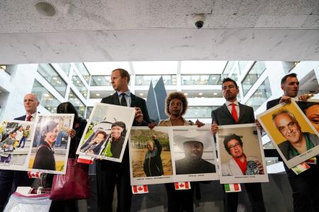 　ボーイング社幹部が米上院で証言するのに合わせ、墜落事故の犠牲者の写真を手に集まった遺族ら＝２０１９年１０月、ワシントン（ロイター＝共同）