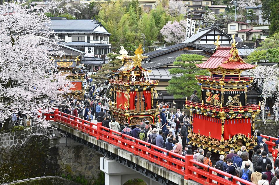 桜の咲く中橋に並んだ祭り屋台＝１５日午前９時３８分、岐阜県高山市内