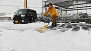店の駐車場の雪をかく従業員＝８日午前８時３２分、岐阜市旦島中