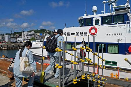 　石川県輪島市の輪島港で、離島舳倉島への旅客船に乗り込む復興作業関係者＝３０日午前