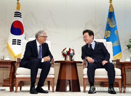 　２１日、韓国ソウルの大統領府でビル・ゲイツ氏（左）と会談する李在明大統領（聯合＝共同）