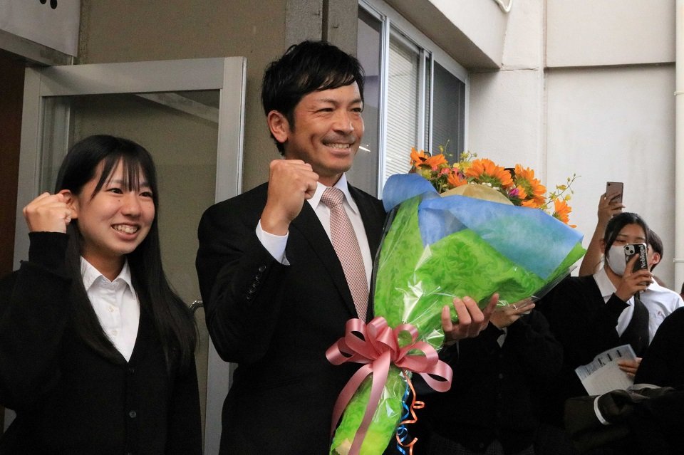 母校を訪問し花束を受け取った松田宣浩選手（中）＝瑞浪市、中京高校
