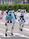 　ハーフマラソン大会で、次々とゴールする人型ロボット＝１９日、北京（共同）