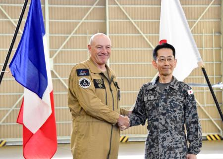 　記者会見後に握手する航空自衛隊の森田雄博航空幕僚長（右）とフランス航空宇宙軍のベランジェ参謀長＝１７日午後、茨城県の空自百里基地