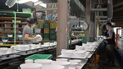 器に異常がないか確かめ、コンベヤーに並べていく従業員ら