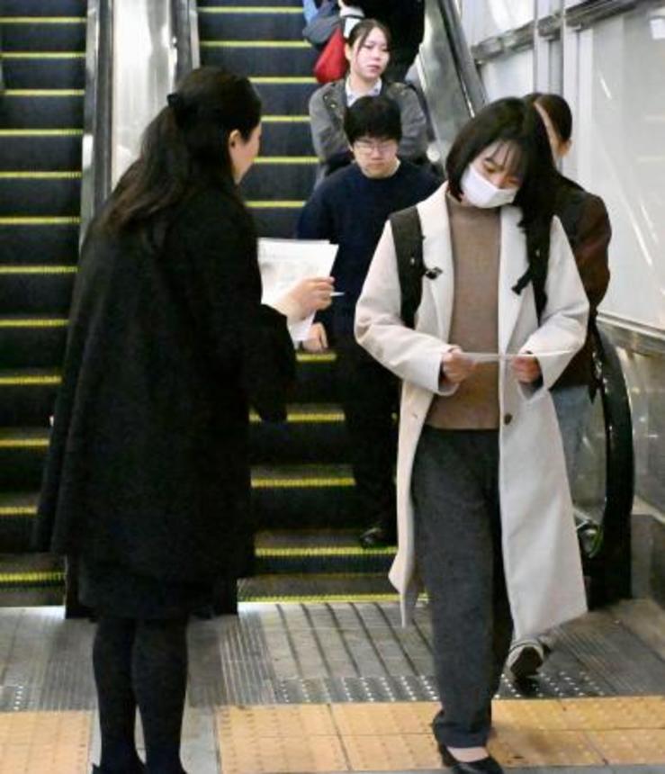 　梶谷恭暉さんの情報提供を求め、ビラを配る母親（左）＝１３日午前、ＪＲ岡山駅前