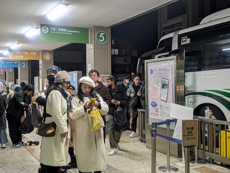 スマートフォンで状況を確かめる観光客＝１日午後６時４２分、高山市花里町、高山濃飛バスセンター