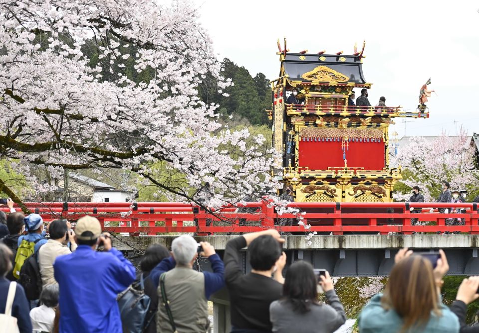 桜が咲く中橋を渡る祭り屋台＝岐阜県高山市内