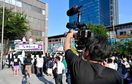 　東京都議選で、地域政党「再生の道」の石丸伸二代表の街頭演説を撮影する“切り抜き職人”の男性＝１９日、東京都中野区