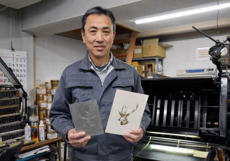 　活版機で印刷した紙製品を手にする中西弘和さん