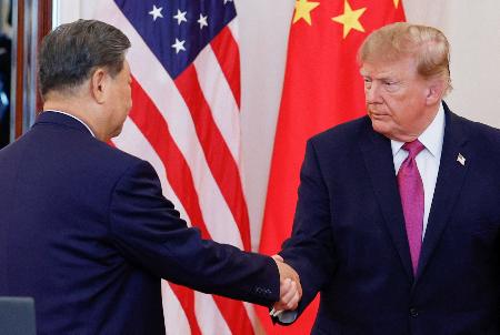 　ワシントンのホワイトハウスで開かれた式典で握手を交わすトランプ米大統領（右）と中国の習近平国家主席＝２４日（ロイター＝共同）