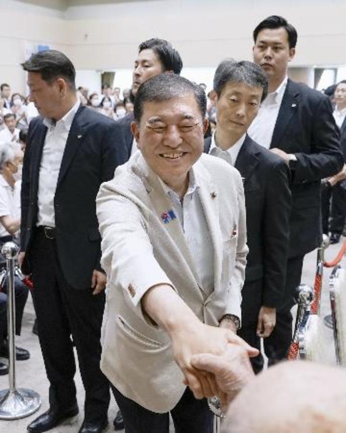 　警戒するＳＰ（警護官）らに囲まれ、支援者と笑顔で握手をする自民党総裁の石破首相＝５日、新潟県長岡市