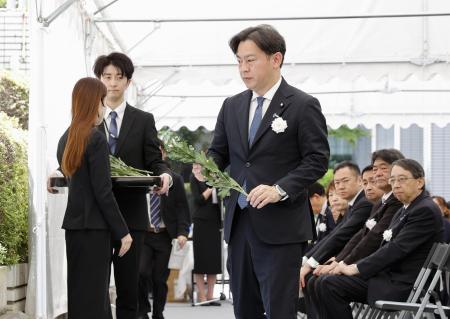 　亡くなったハンセン病患者や元患者の追悼と名誉回復のための式典で、献花に臨む福岡厚労相＝１９日午前、厚労省