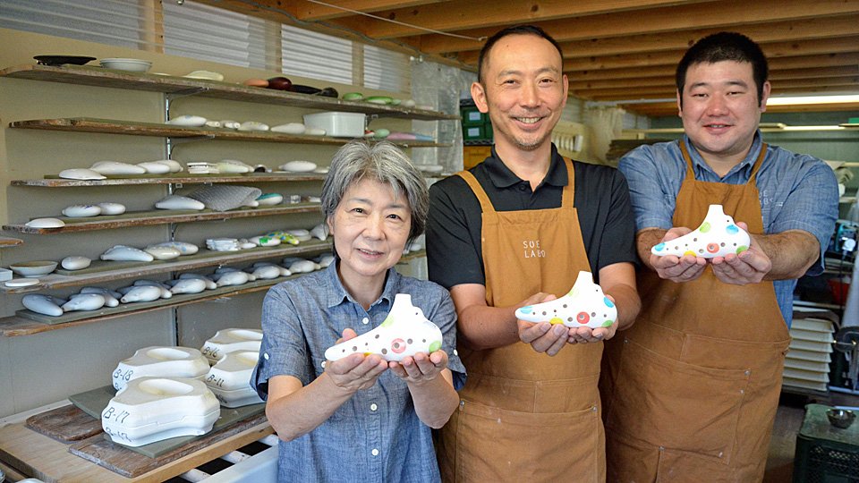 鈴木夏織さん（左）の監修で作り上げた高精度の美濃焼オカリナを示す伊藤弘典さん（中央）と加藤和貴さん＝瑞浪市陶町猿爪、スエラボ