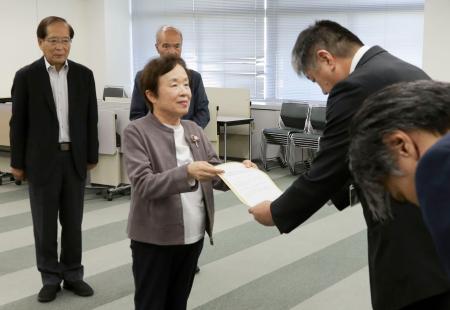 　富山市役所で中田祐一企画管理部次長（右）に要請書を手渡す市民団体の広瀬妙子代表委員＝８日午後