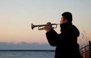 　福島県富岡町の海岸でトランペットを演奏する福田純也さん＝１１日午前６時３分