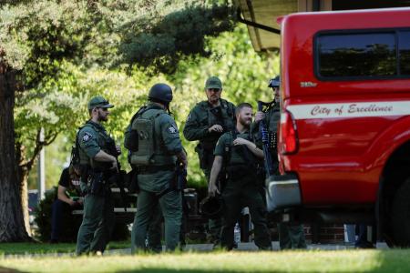 　２９日、米アイダホ州コーダリーンで消防士らが銃撃された現場近くに集まった捜査当局者（ロイター＝共同）