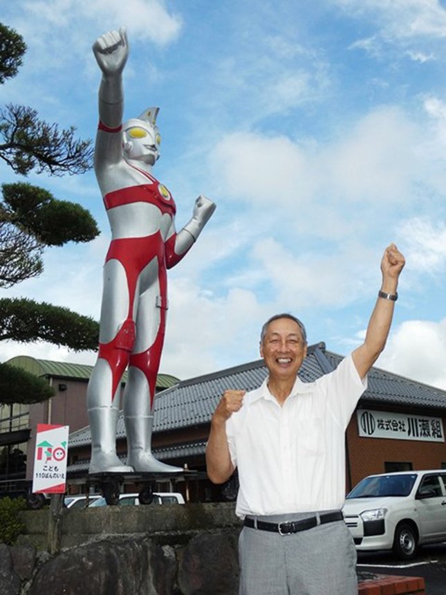 元少年兵の創業者が置いたウルトラマンＡ。その遺志を受け継いで拳を掲げる川瀬嘉洋社長＝羽島市小熊町、川瀬組
