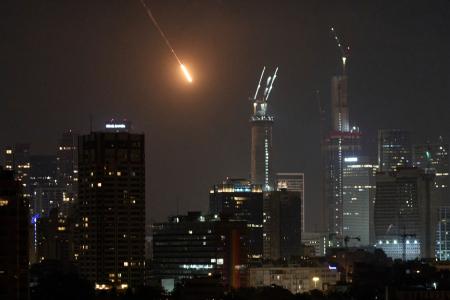 　１４日、イスラエル中部テルアビブに落下する飛翔（ひしょう）体（ＡＰ＝共同）