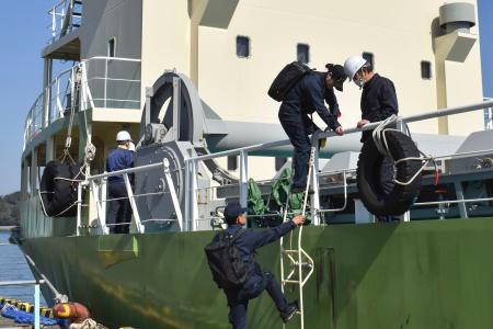 　貨物船に立ち入る運輸安全委員会の船舶事故調査官＝２２日午後、三重県鳥羽市