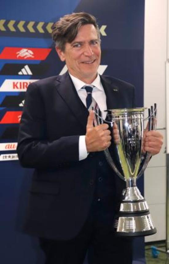 　サッカー女子日本代表のアジア・カップ優勝報告の記者会見で、笑顔で優勝カップを持つニールセン監督＝２３日、東京都文京区
