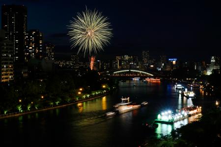 　奉納花火が夜空を彩り、大川を船が行き交う天神祭の「船渡御」＝２５日夜、大阪市